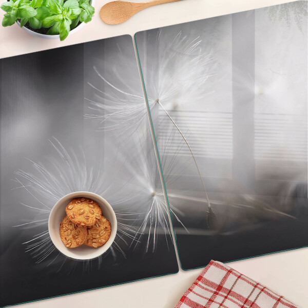 Glass chopping board Fluffy dandelions against the window background