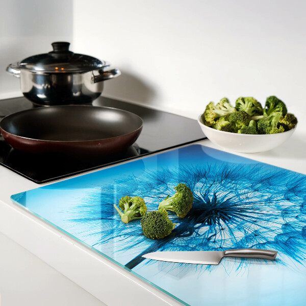 Chopping board glass Dandelion on a blue background