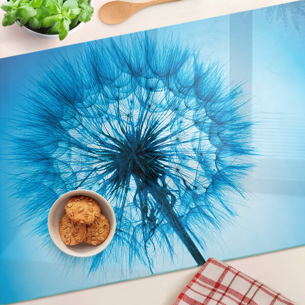 Chopping board glass Dandelion on a blue background