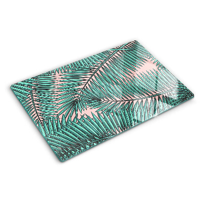 Glass cutting board Palm leaves on a pink background