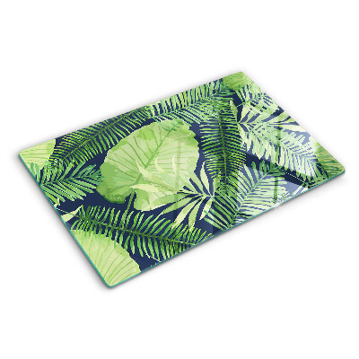 Chopping board glass Tropical leaves on a dark background
