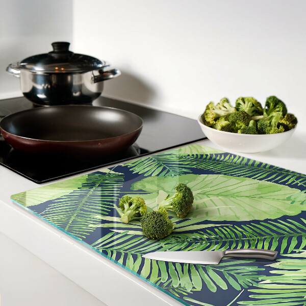 Chopping board glass Tropical leaves on a dark background
