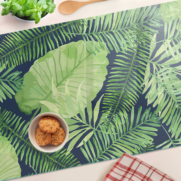 Chopping board glass Tropical leaves on a dark background