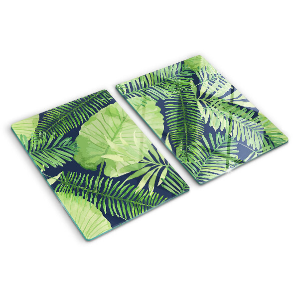 Chopping board glass Tropical leaves on a dark background