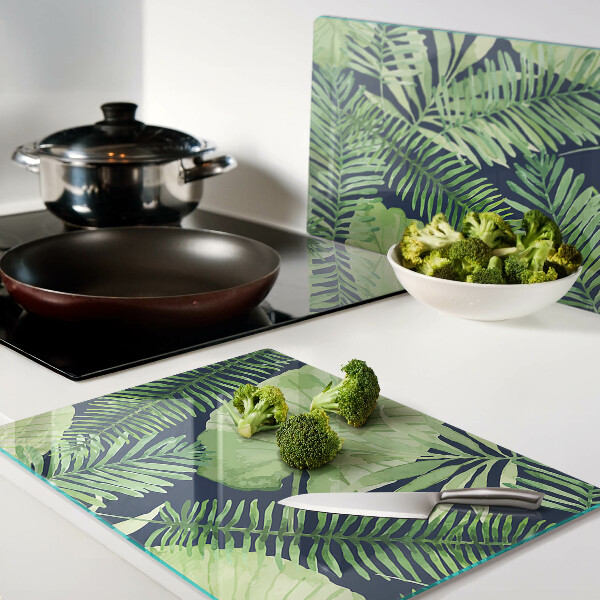 Chopping board glass Tropical leaves on a dark background
