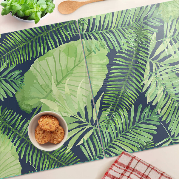 Chopping board glass Tropical leaves on a dark background