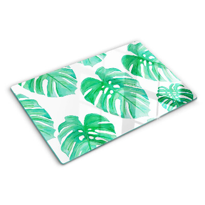 Glass cutting board Monstera leaves on a white background