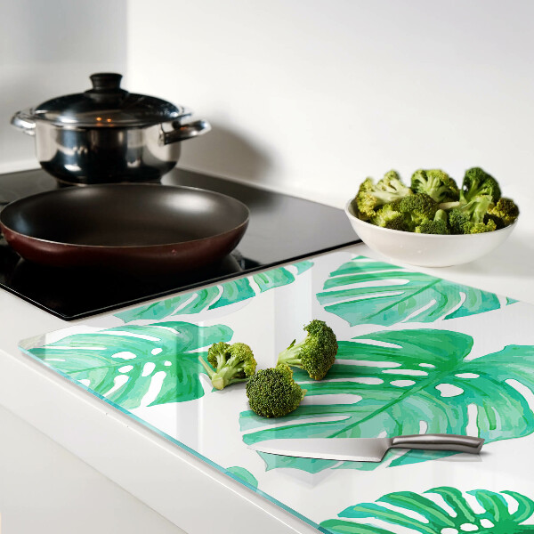 Glass cutting board Monstera leaves on a white background