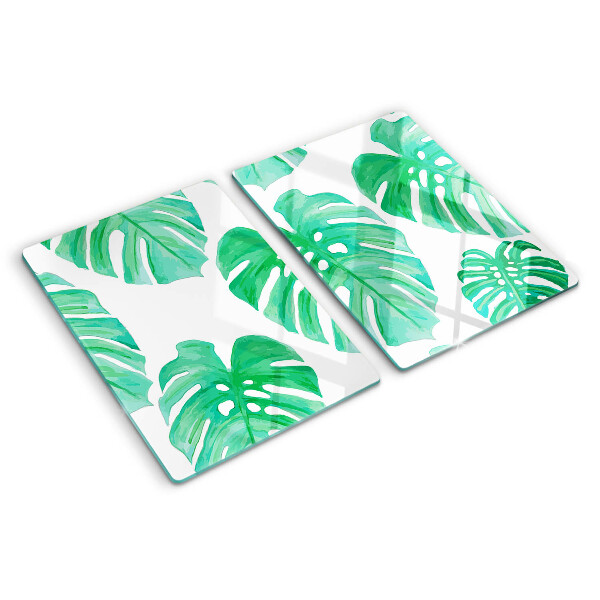 Glass cutting board Monstera leaves on a white background