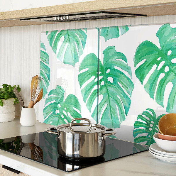 Glass cutting board Monstera leaves on a white background