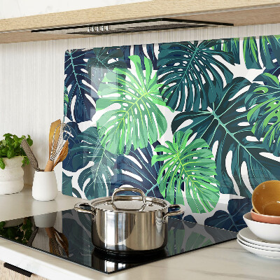 Glass chopping board Monstera leaves on a tropical background