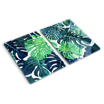 Glass chopping board Monstera leaves on a tropical background