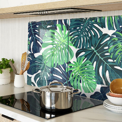 Glass chopping board Monstera leaves on a tropical background