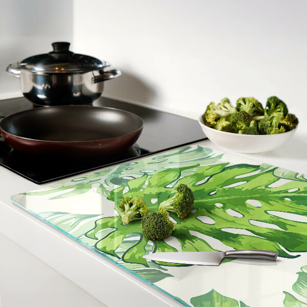 Glass kitchen board Monstera leaves on a light background