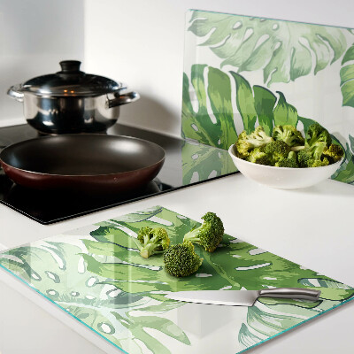 Glass kitchen board Monstera leaves on a light background
