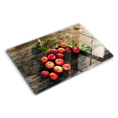 Chopping board glass Apples on a wooden background