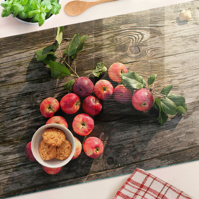 Chopping board glass Apples on a wooden background