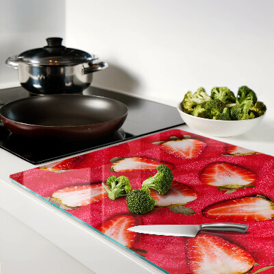 Chopping board glass Strawberries on a pink background