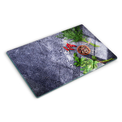 Glass chopping board Herbs and spices on a stone background