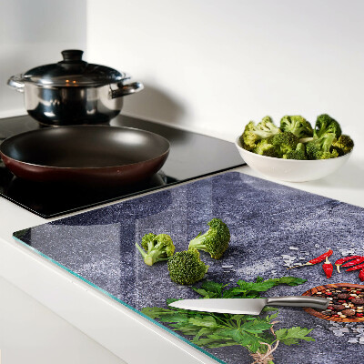 Glass chopping board Herbs and spices on a stone background