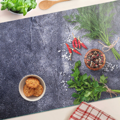 Glass chopping board Herbs and spices on a stone background