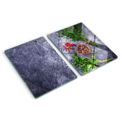 Glass chopping board Herbs and spices on a stone background