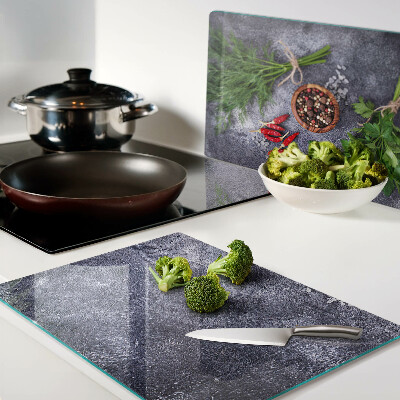 Glass chopping board Herbs and spices on a stone background