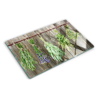 Glass cutting board Herbs on a wooden background
