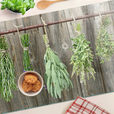 Glass cutting board Herbs on a wooden background