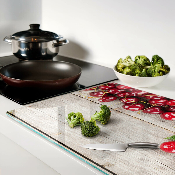 Glass cutting board Cherries on a wooden background