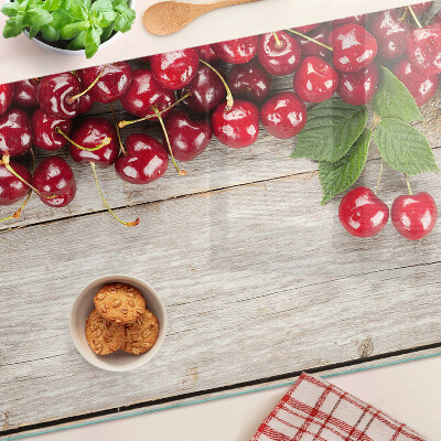 Glass cutting board Cherries on a wooden background