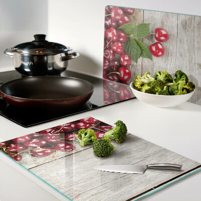 Glass cutting board Cherries on a wooden background