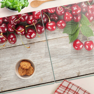 Glass cutting board Cherries on a wooden background