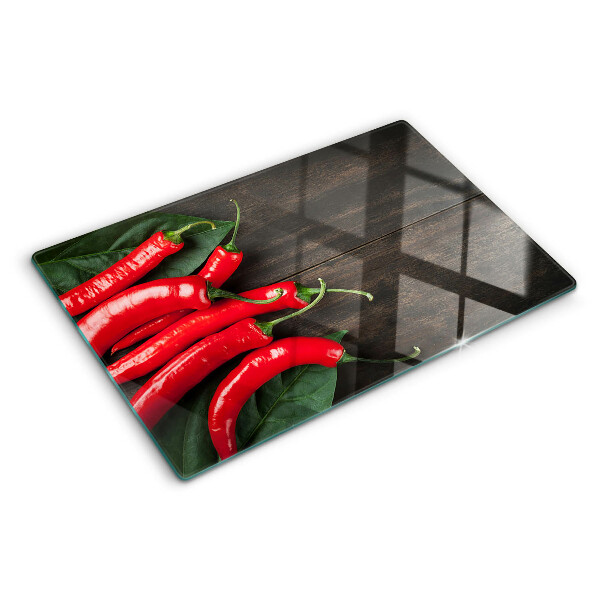 Glass cutting board Chili peppers on a wooden background