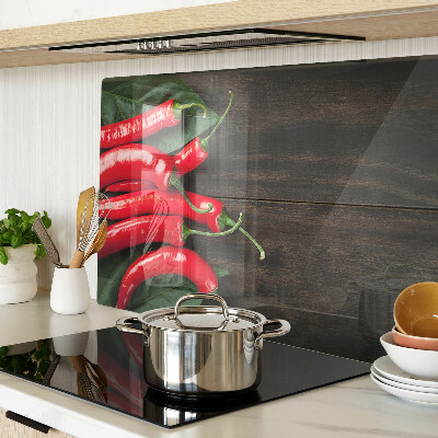 Glass cutting board Chili peppers on a wooden background