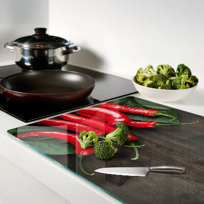 Glass cutting board Chili peppers on a wooden background