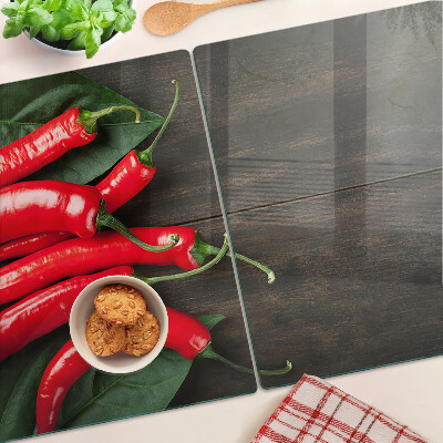 Glass cutting board Chili peppers on a wooden background
