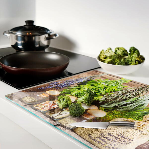 Chopping board glass Herbs and spices on a wood background