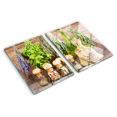 Chopping board glass Herbs and spices on a wood background