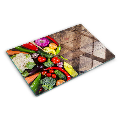 Glass cutting board Vegetables on a wooden background