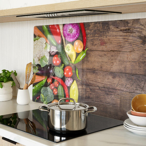 Glass cutting board Vegetables on a wooden background
