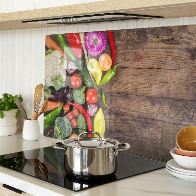 Glass cutting board Vegetables on a wooden background