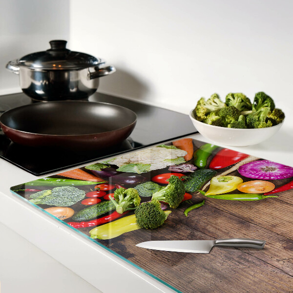 Glass cutting board Vegetables on a wooden background