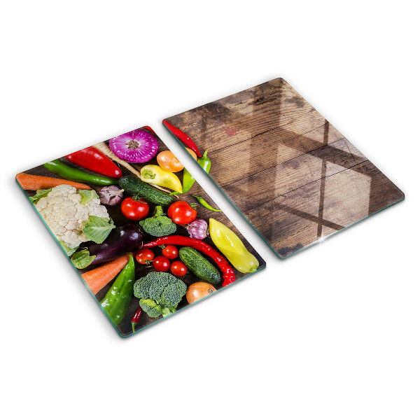 Glass cutting board Vegetables on a wooden background