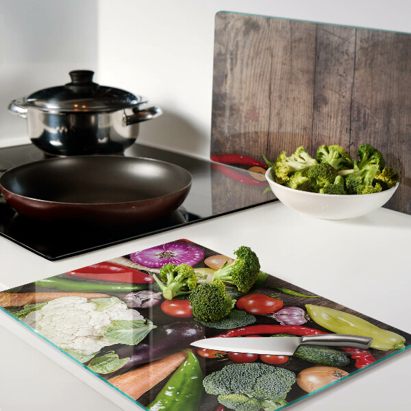 Glass cutting board Vegetables on a wooden background
