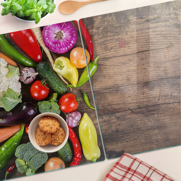 Glass cutting board Vegetables on a wooden background