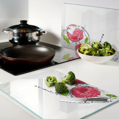 Chopping board glass Raspberries in water with leaves