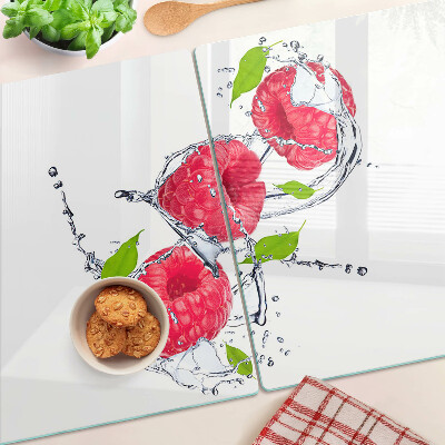 Chopping board glass Raspberries in water with leaves