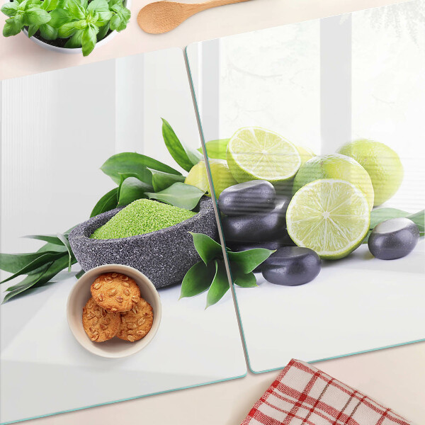 Chopping board glass Lemons and grapes on a green background