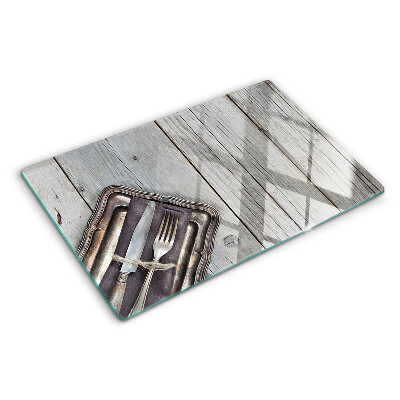 Chopping board glass Rustic cutlery on a wooden background